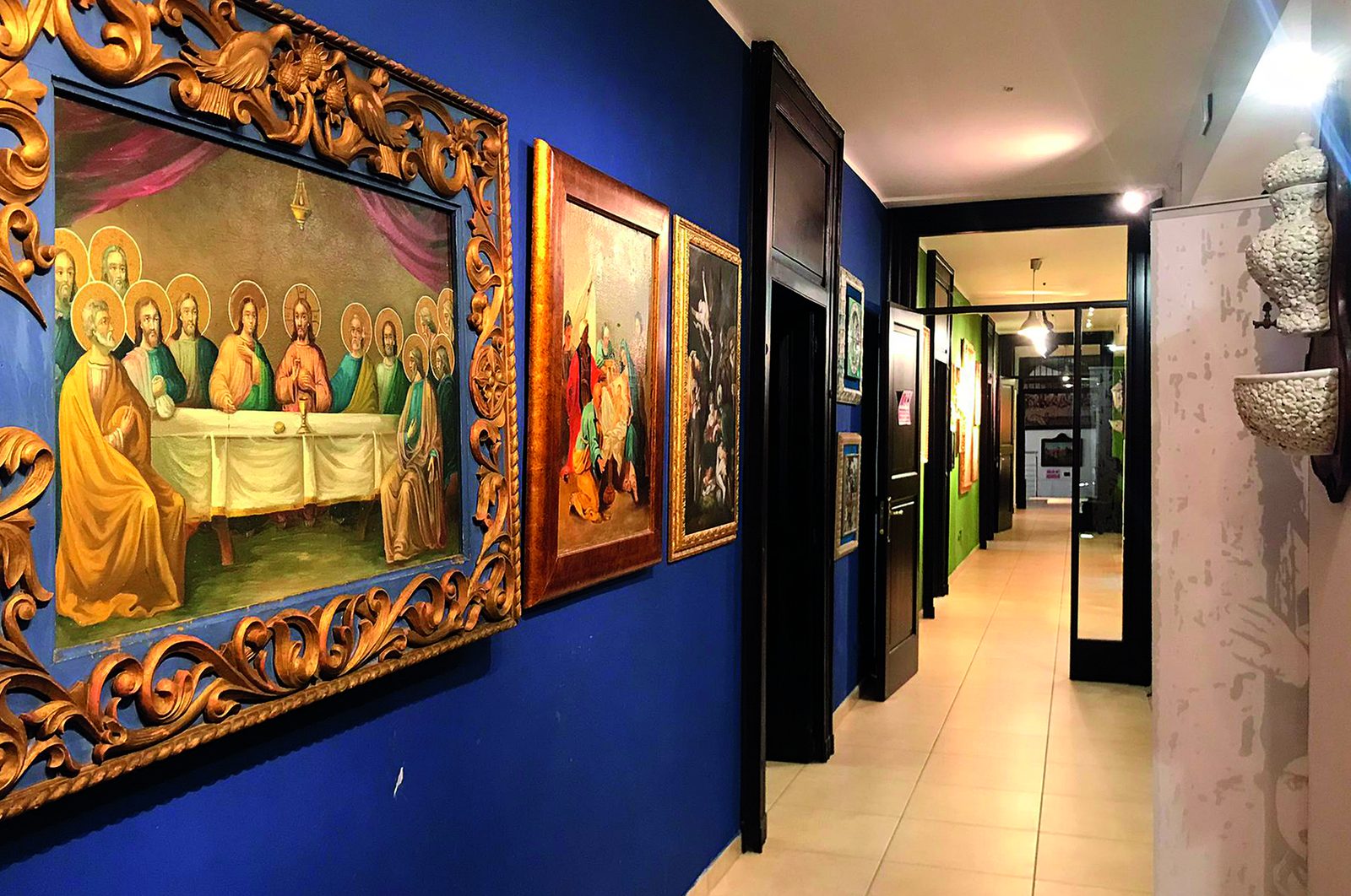 Il corridoio del Palazzo con i dipinti e le pareti blu
